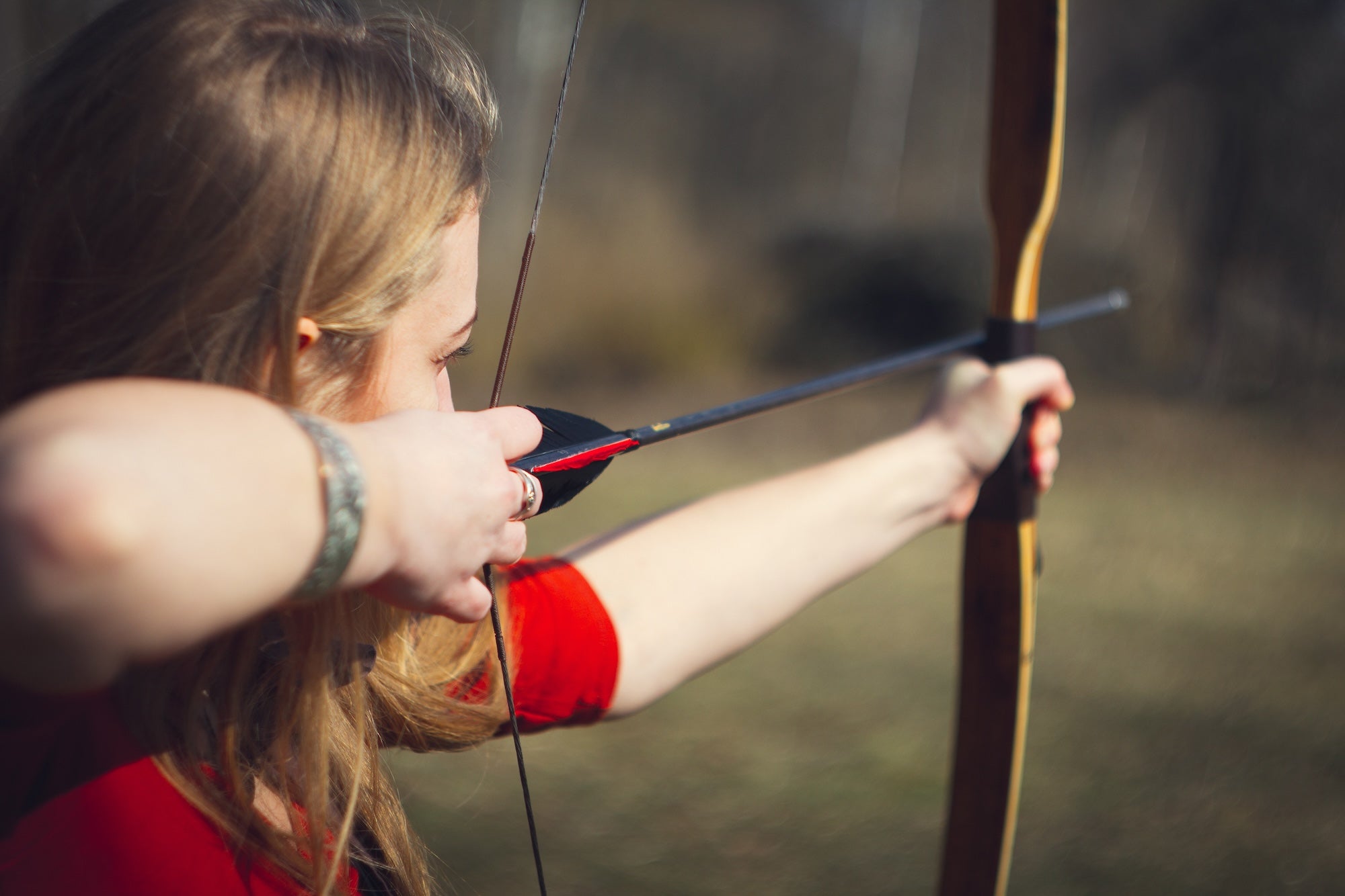 Archer practicing accuracy with a traditional bow during outdoor training using realistic 3D archery targets